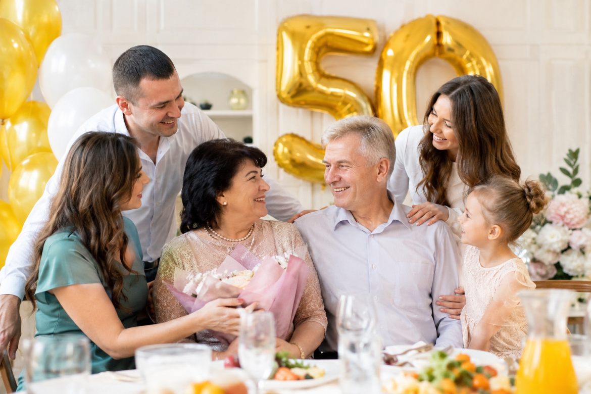 Сім'я вітає батьків з 50-річним ювілеєм за святковим столом з кульками